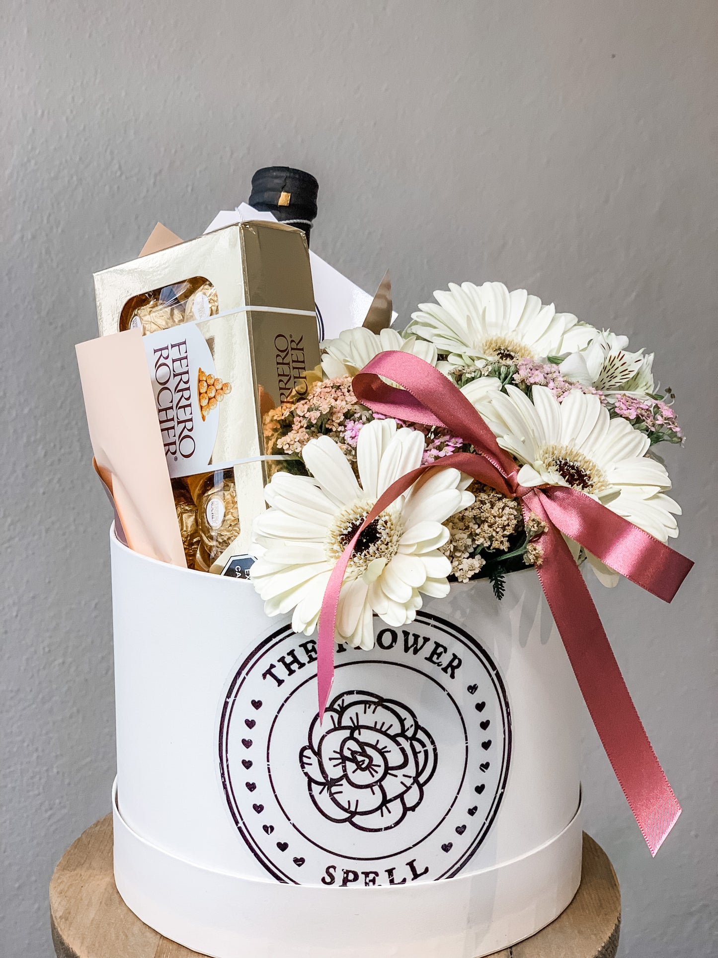 Caja con Gerberas, botella, chocolates.