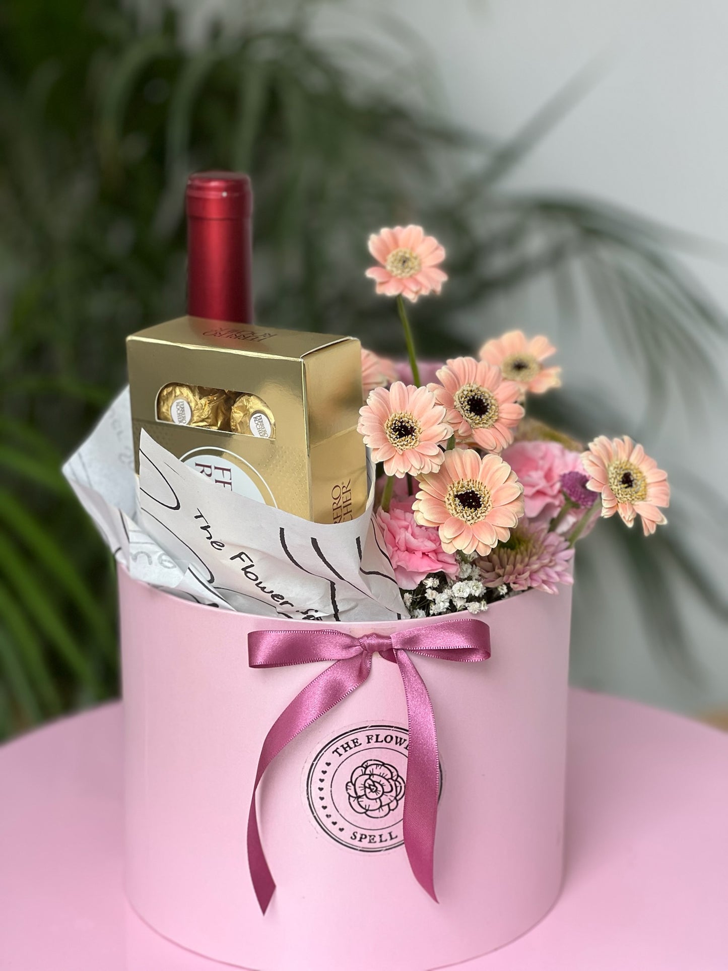 Caja con Gerberas, botella, chocolates.