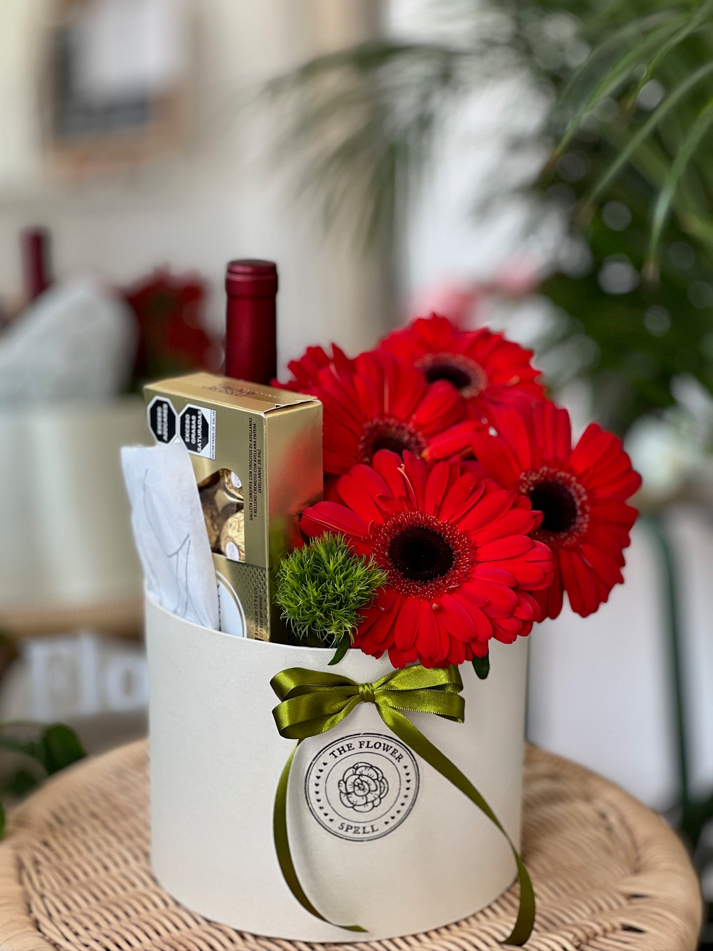 Caja con Gerberas, botella, chocolates.