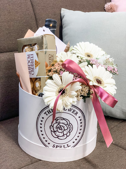 Caja con Gerberas, botella, chocolates.