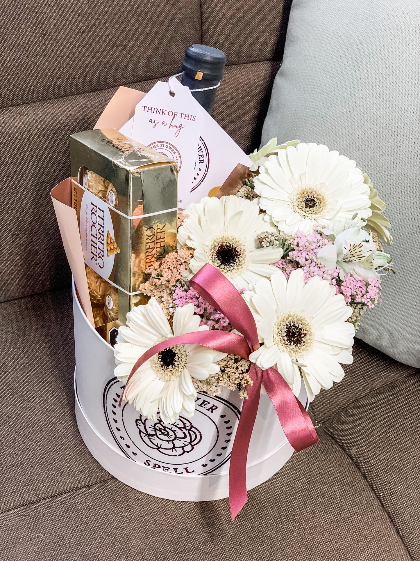 Caja con Gerberas, botella, chocolates.