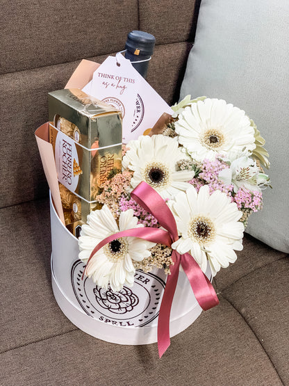 Caja con Gerberas, botella, chocolates.